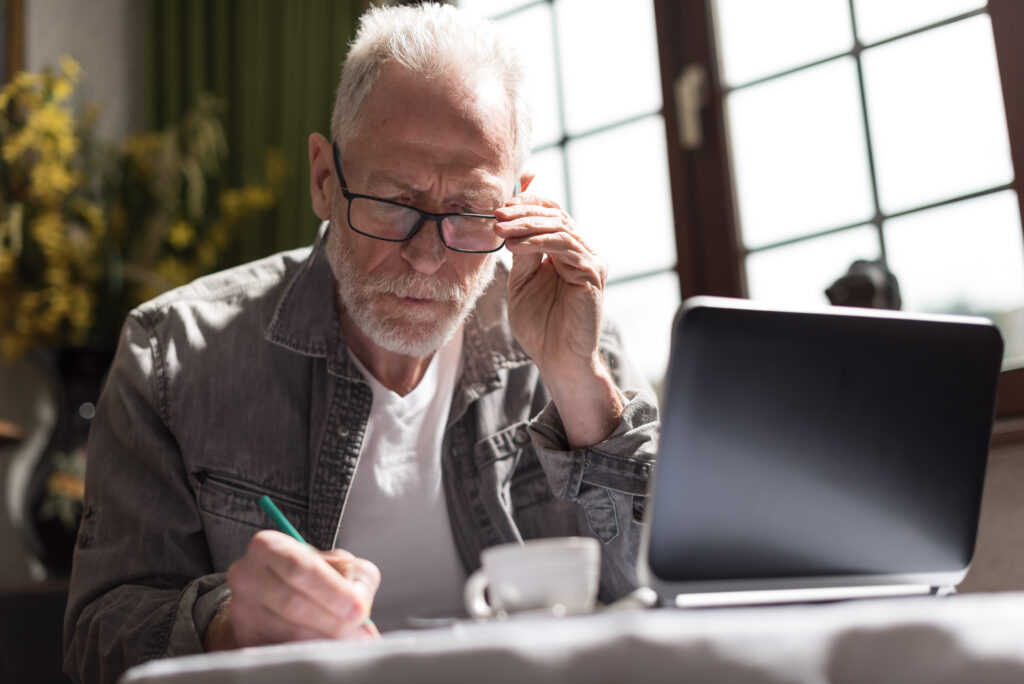older man writing down notes